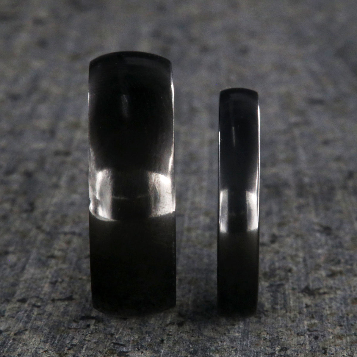 8mm and 4mm wide matching black zirconium wedding ring set with a polished finish and rounded profile
