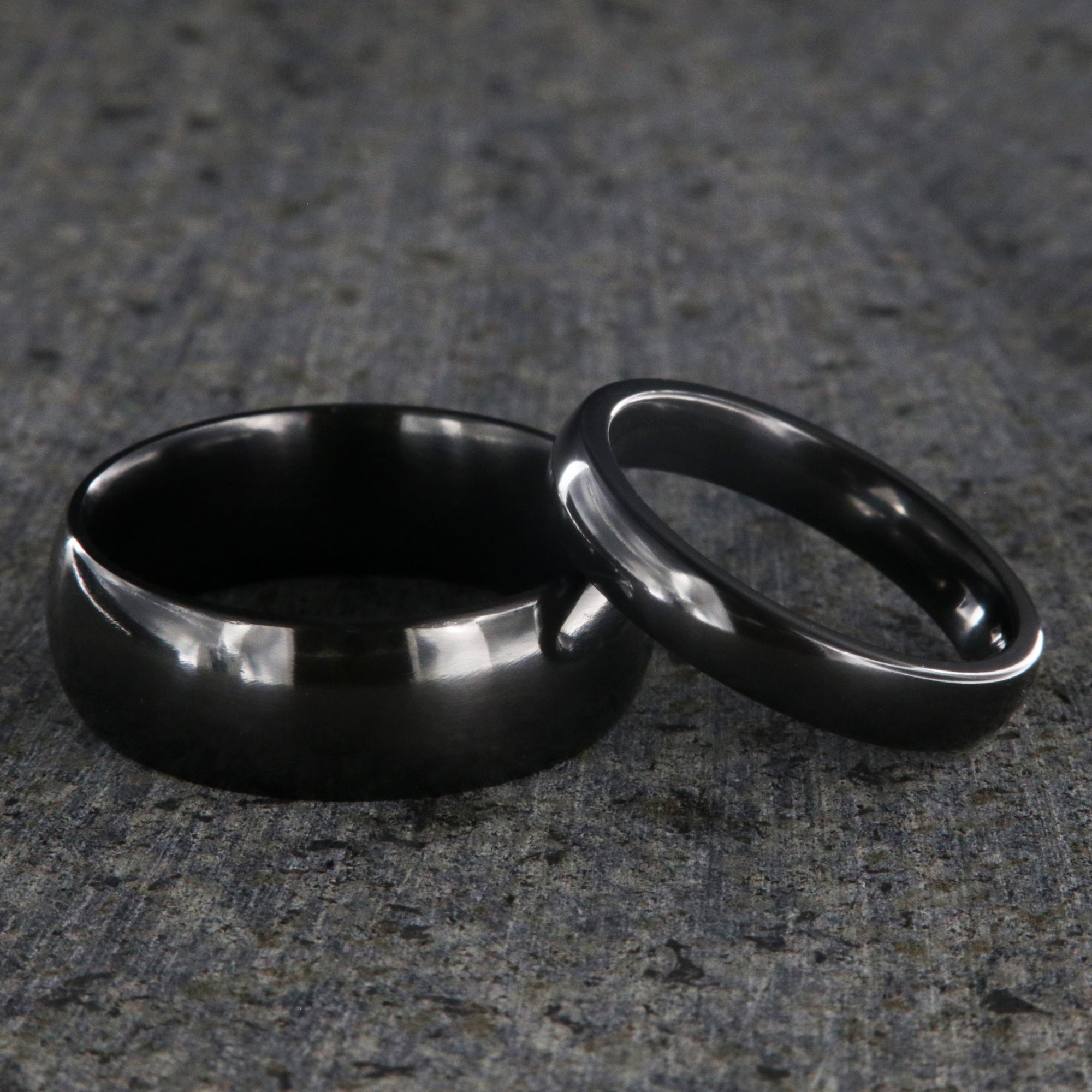 8mm and 4mm wide matching black zirconium wedding ring set with a polished finish and rounded profile