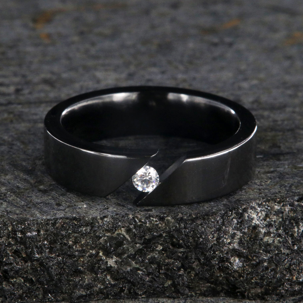 6mm wide black zirconium tension set ring with 3mm round gemstone and diagonal tension