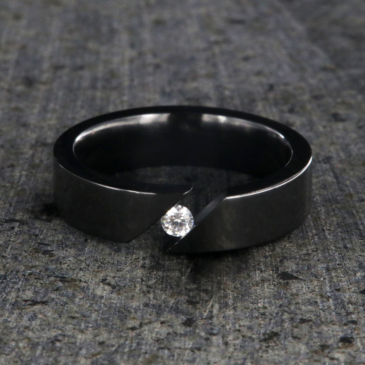 6mm wide black zirconium tension set ring with 3mm round gemstone and diagonal tension
