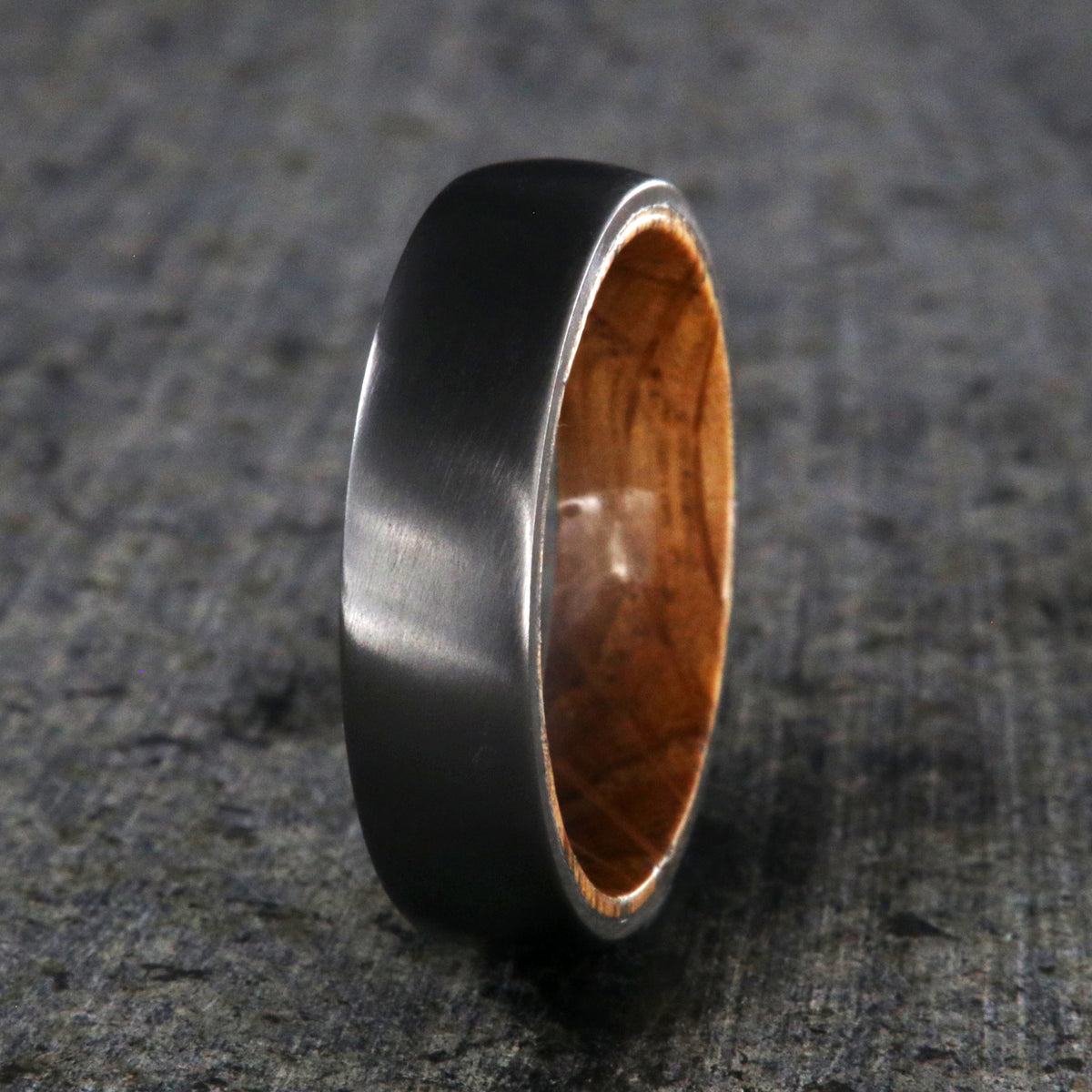 6mm wide black zirconium wedding band with a whiskey barrel sleeve