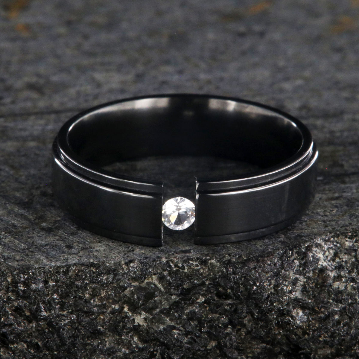 6mm wide black zirconium tension set ring with a 3mm round gemstone