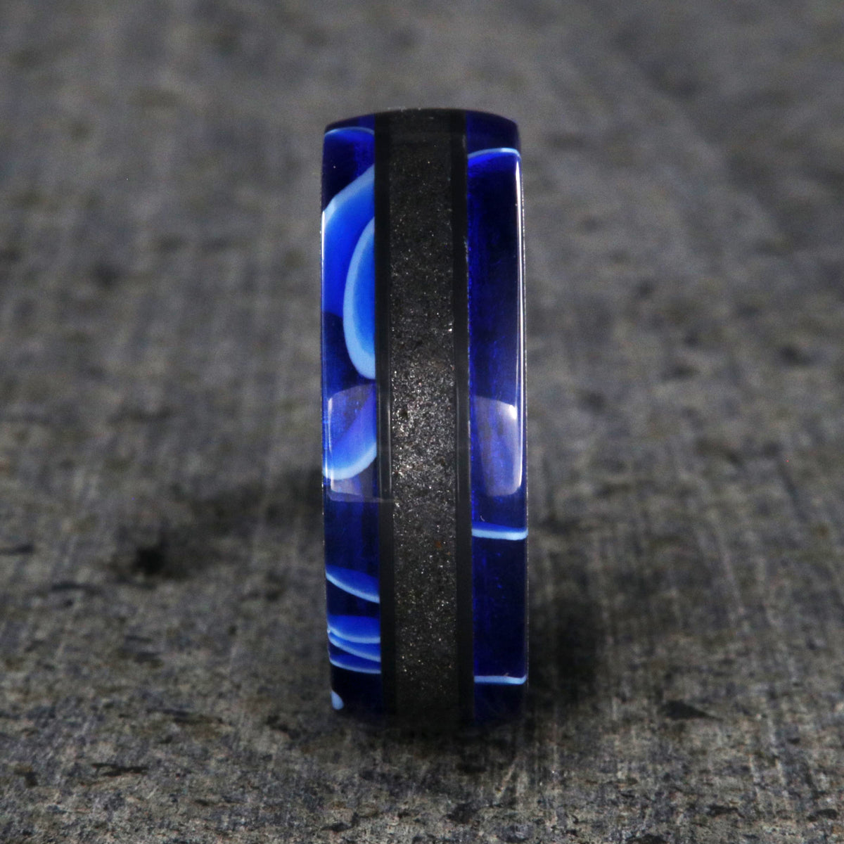 7mm wide swirled blue acrylic ring with black stardust center inlay and black zirconium sleeve