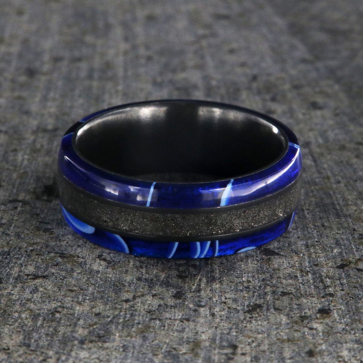 7mm wide swirled blue acrylic ring with black stardust center inlay and black zirconium sleeve