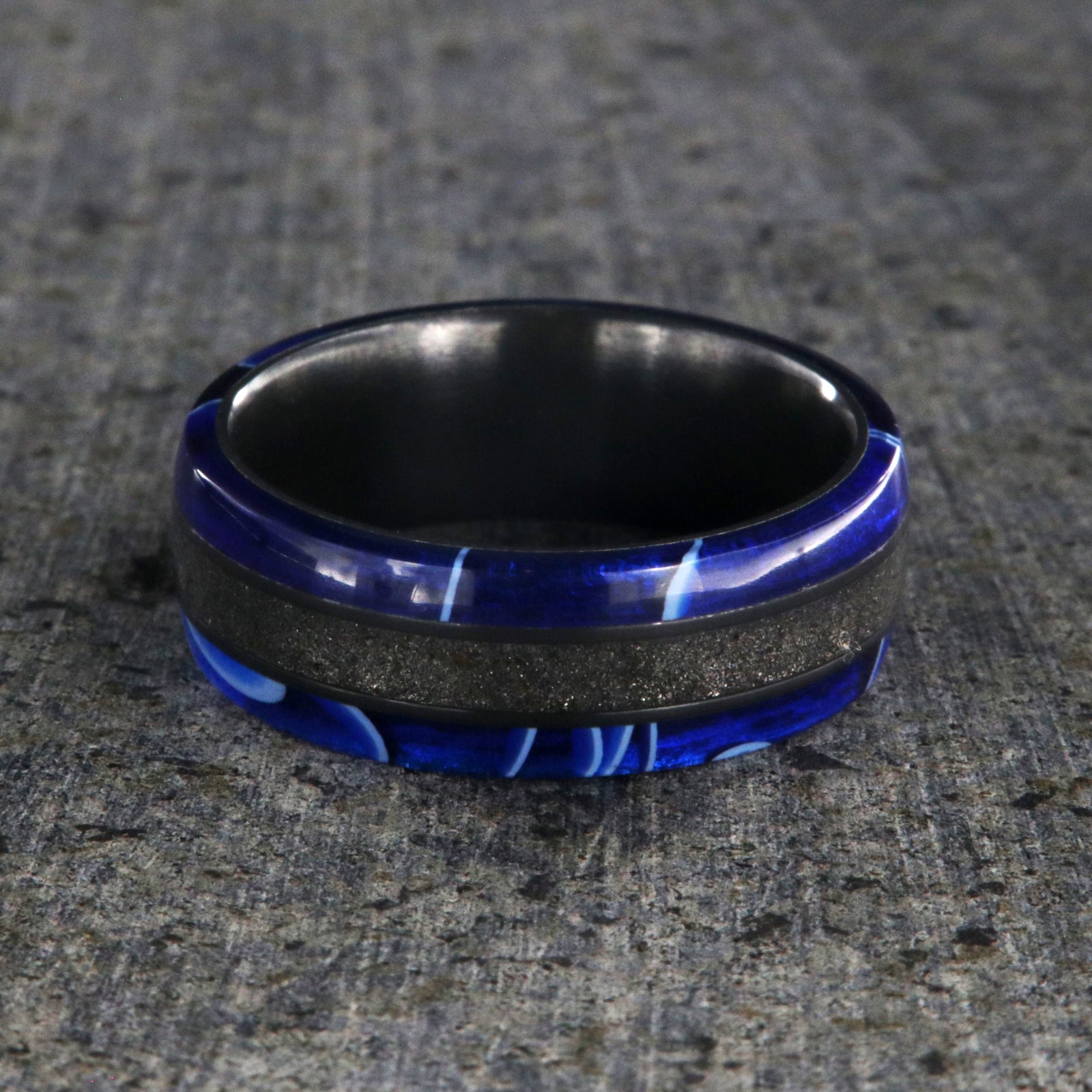 7mm wide swirled blue acrylic ring with black stardust center inlay and black zirconium sleeve