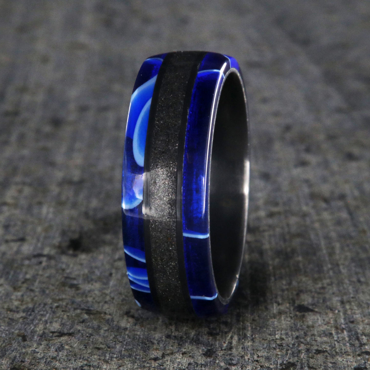 7mm wide swirled blue acrylic ring with black stardust center inlay and black zirconium sleeve