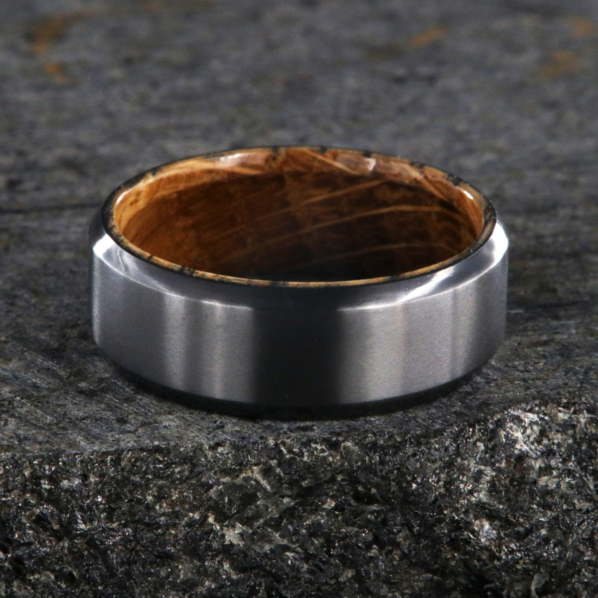 8mm wide black zirconium wedding band with beveled edges and a whiskey barrel sleeve