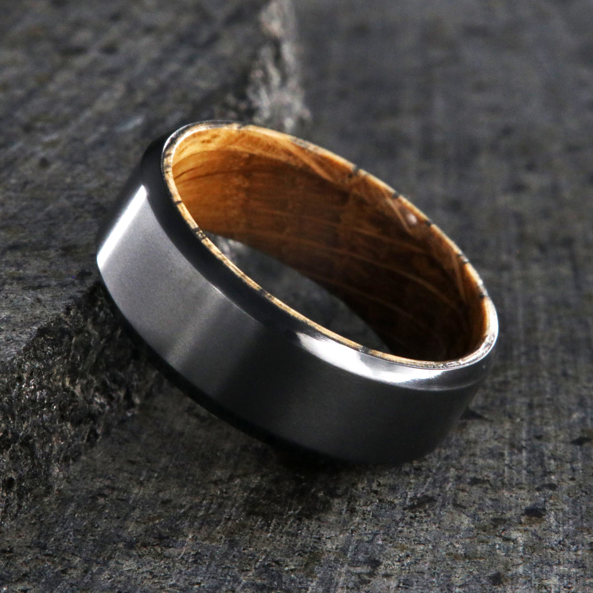 8mm wide black zirconium wedding band with beveled edges and a whiskey barrel sleeve