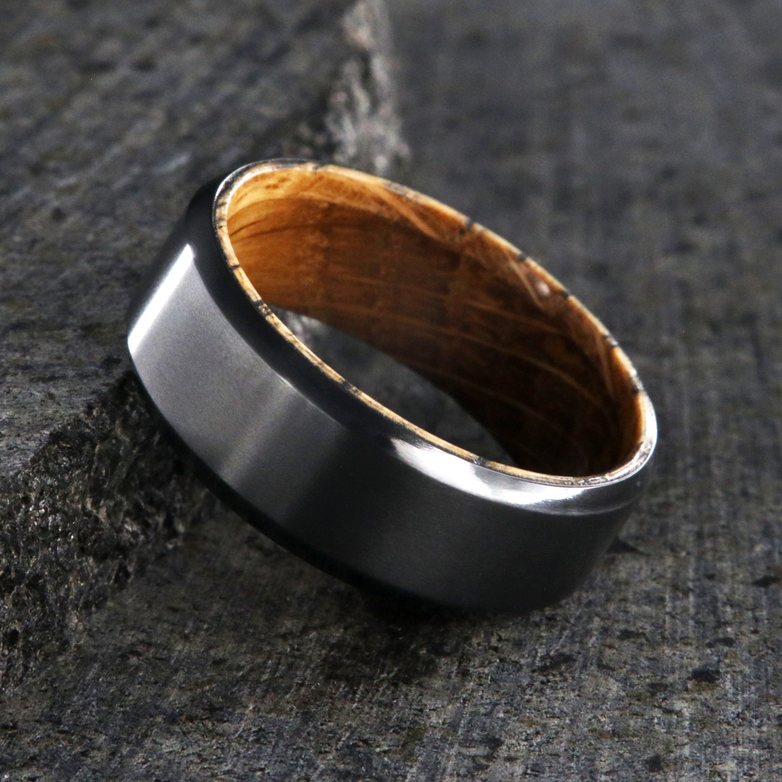 8mm wide black zirconium wedding band with beveled edges and a whiskey barrel sleeve