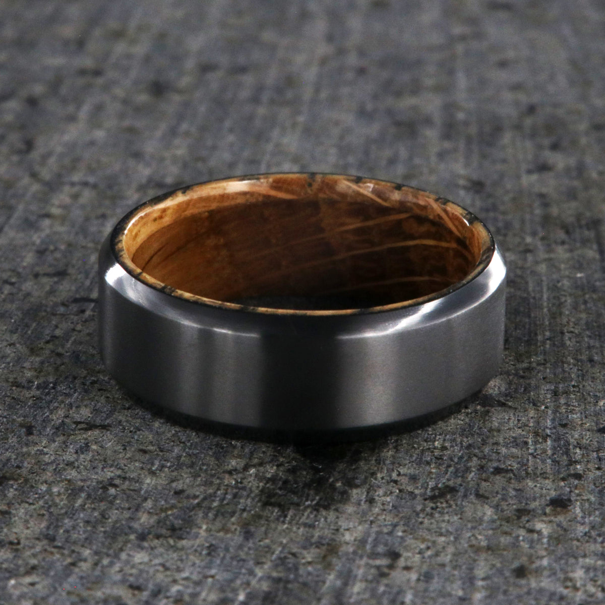 8mm wide black zirconium wedding band with beveled edges and a whiskey barrel sleeve