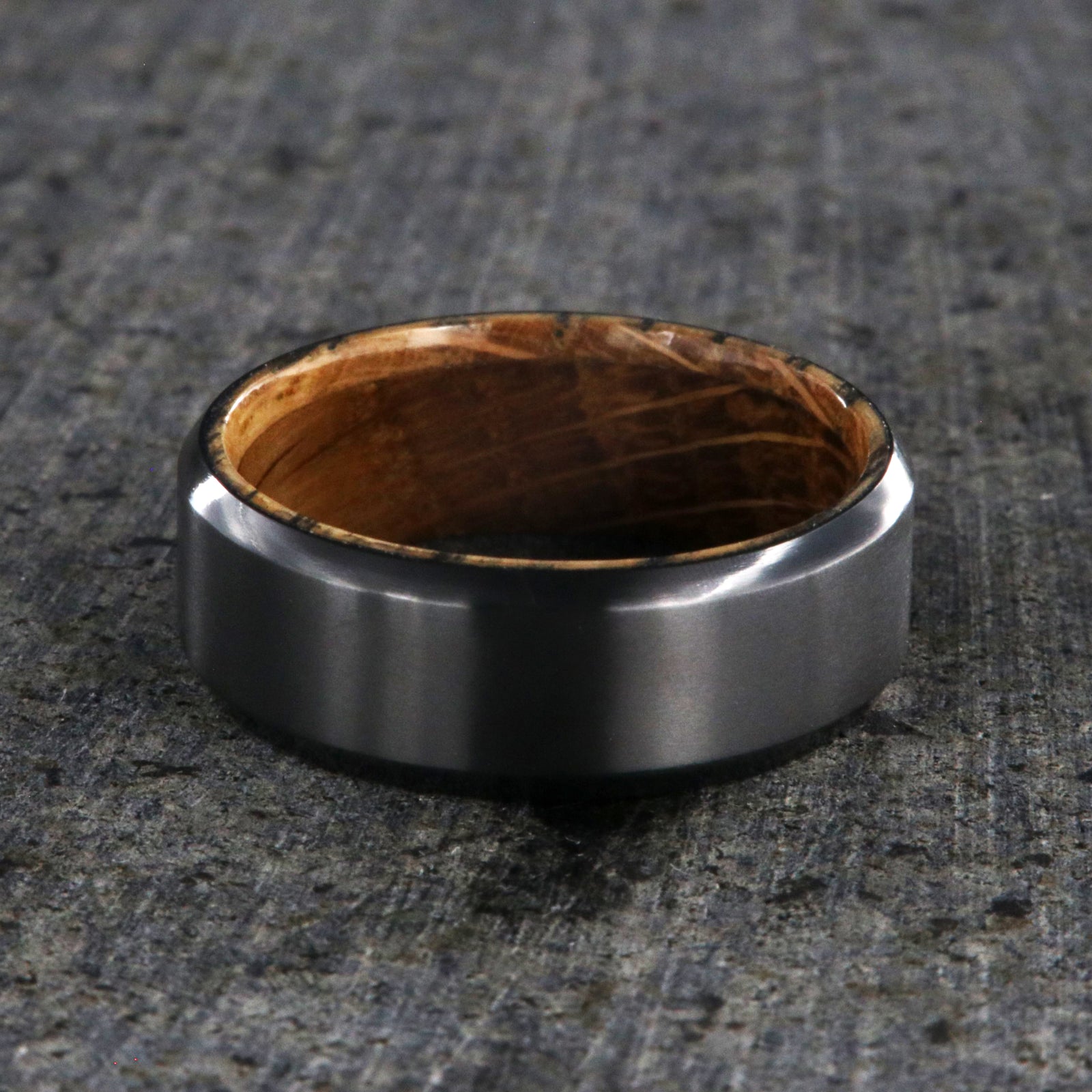8mm wide black zirconium wedding band with beveled edges and a whiskey barrel sleeve