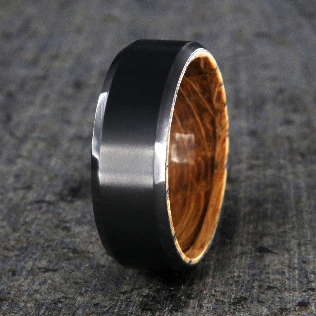 8mm wide black zirconium wedding band with beveled edges and a whiskey barrel sleeve