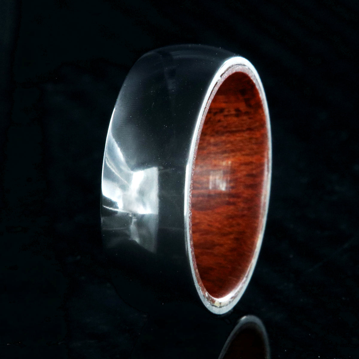 8mm wide black zirconium ring with a polish finish and bloodwood sleeve