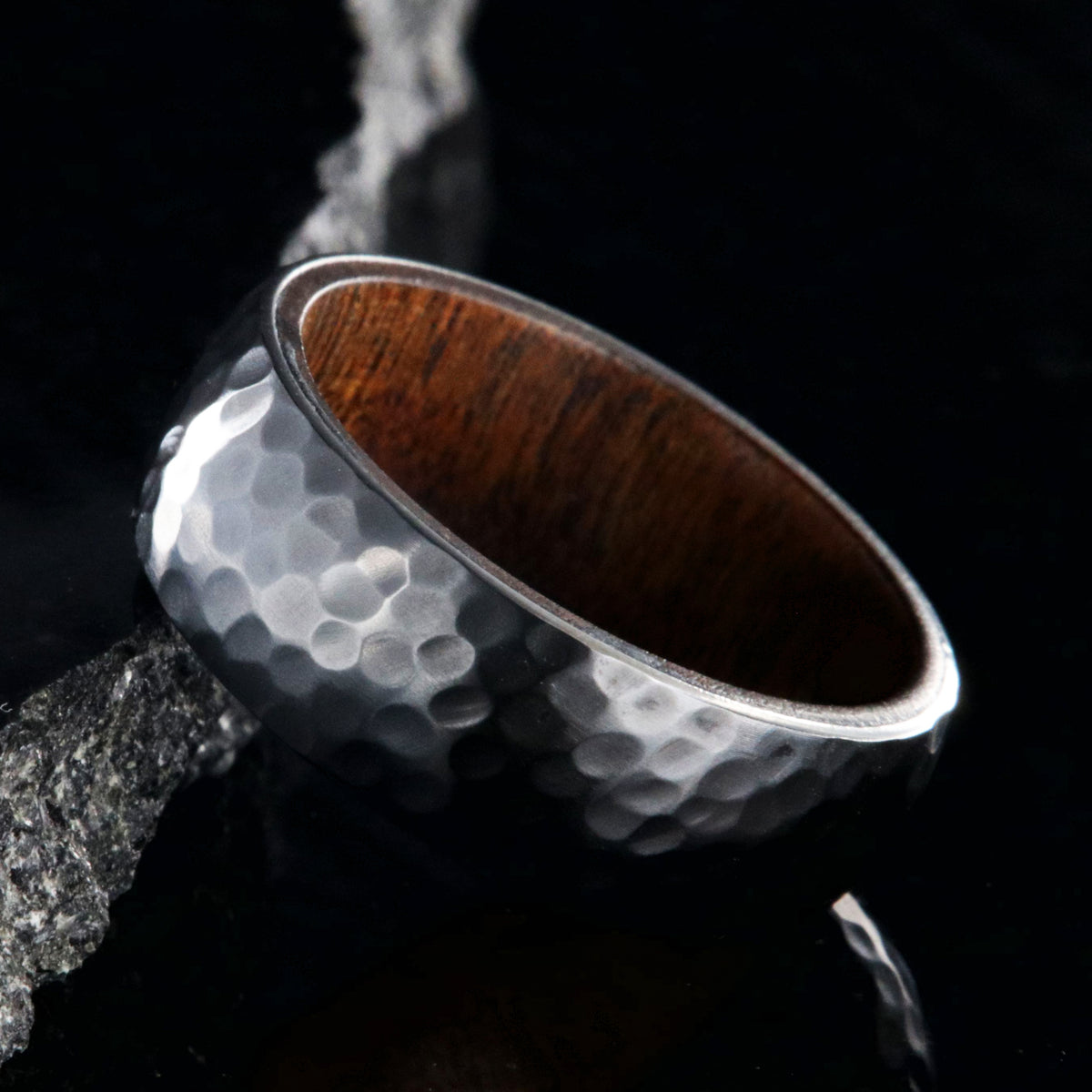 8mm wide black zirconium ring with a hammered finish and a rosewood sleeve