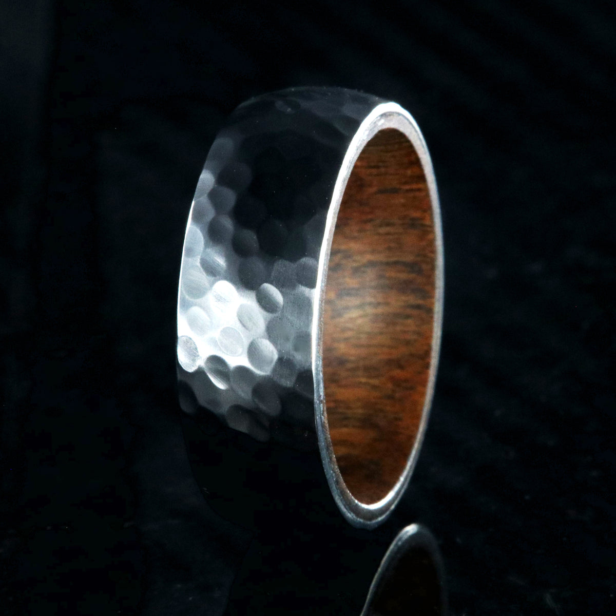 8mm wide black zirconium ring with a hammered finish and a rosewood sleeve