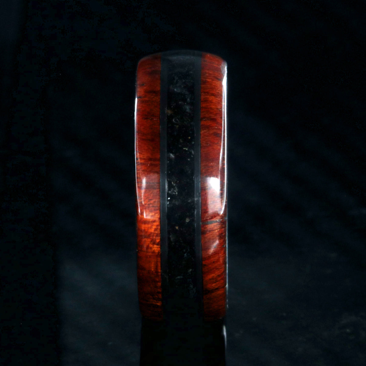 8mm wide wedding band with bloodwood edges with a dark dinosaur bone inlay and a black zirconium sleeve