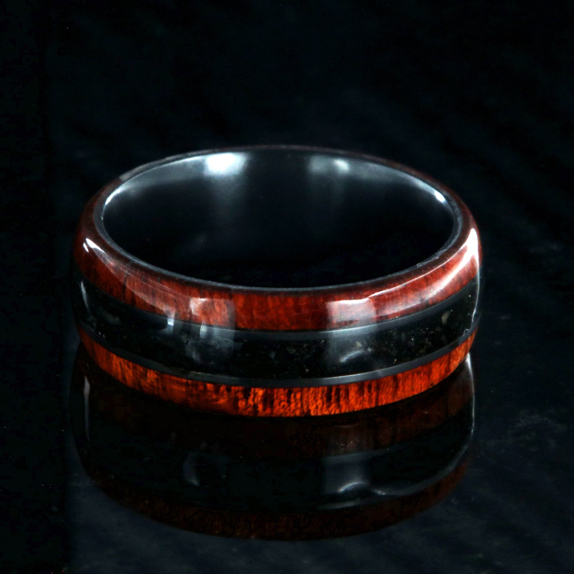 8mm wide wedding band with bloodwood edges with a dark dinosaur bone inlay and a black zirconium sleeve