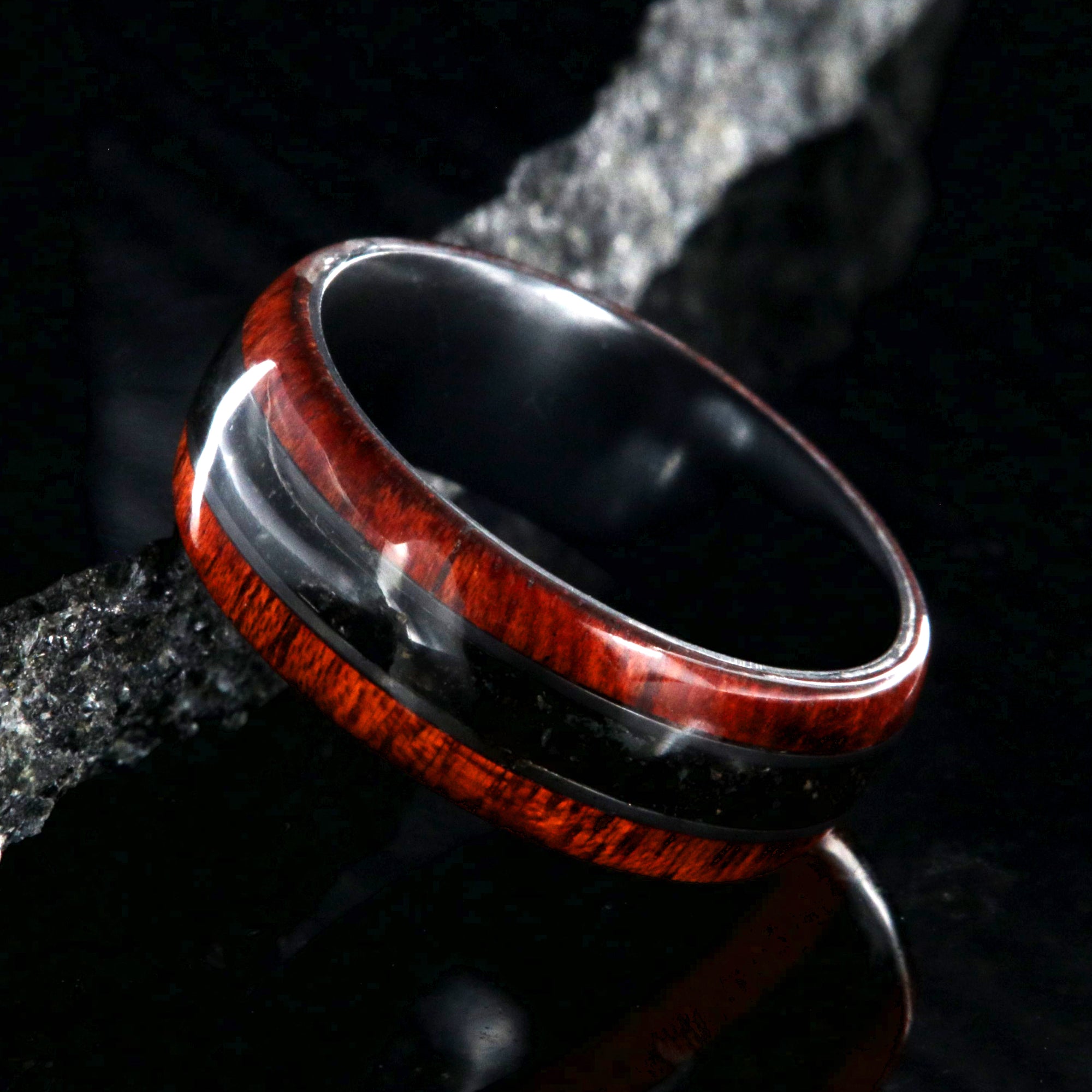 8mm wide wedding band with bloodwood edges with a dark dinosaur bone inlay and a black zirconium sleeve