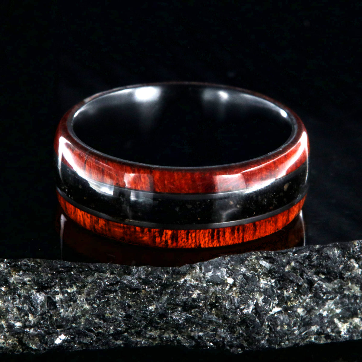 8mm wide wedding band with bloodwood edges with a dark dinosaur bone inlay and a black zirconium sleeve