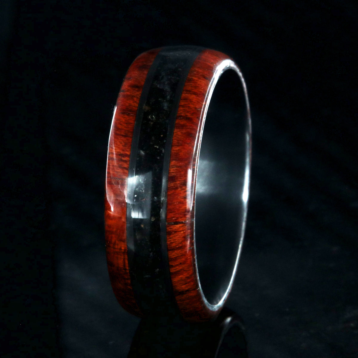 8mm wide wedding band with bloodwood edges with a dark dinosaur bone inlay and a black zirconium sleeve