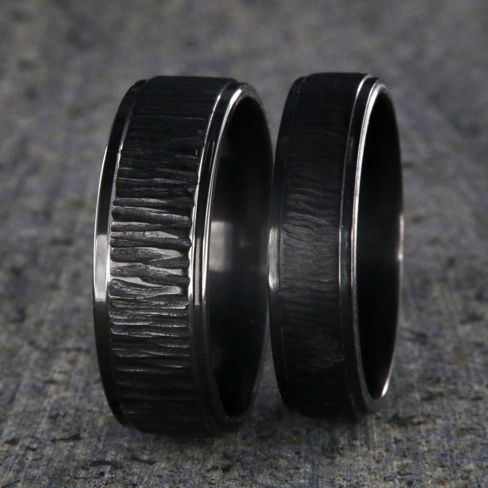 8mm and 6mm wide matching black zirconium wedding ring set with a raised center and tree bark finish