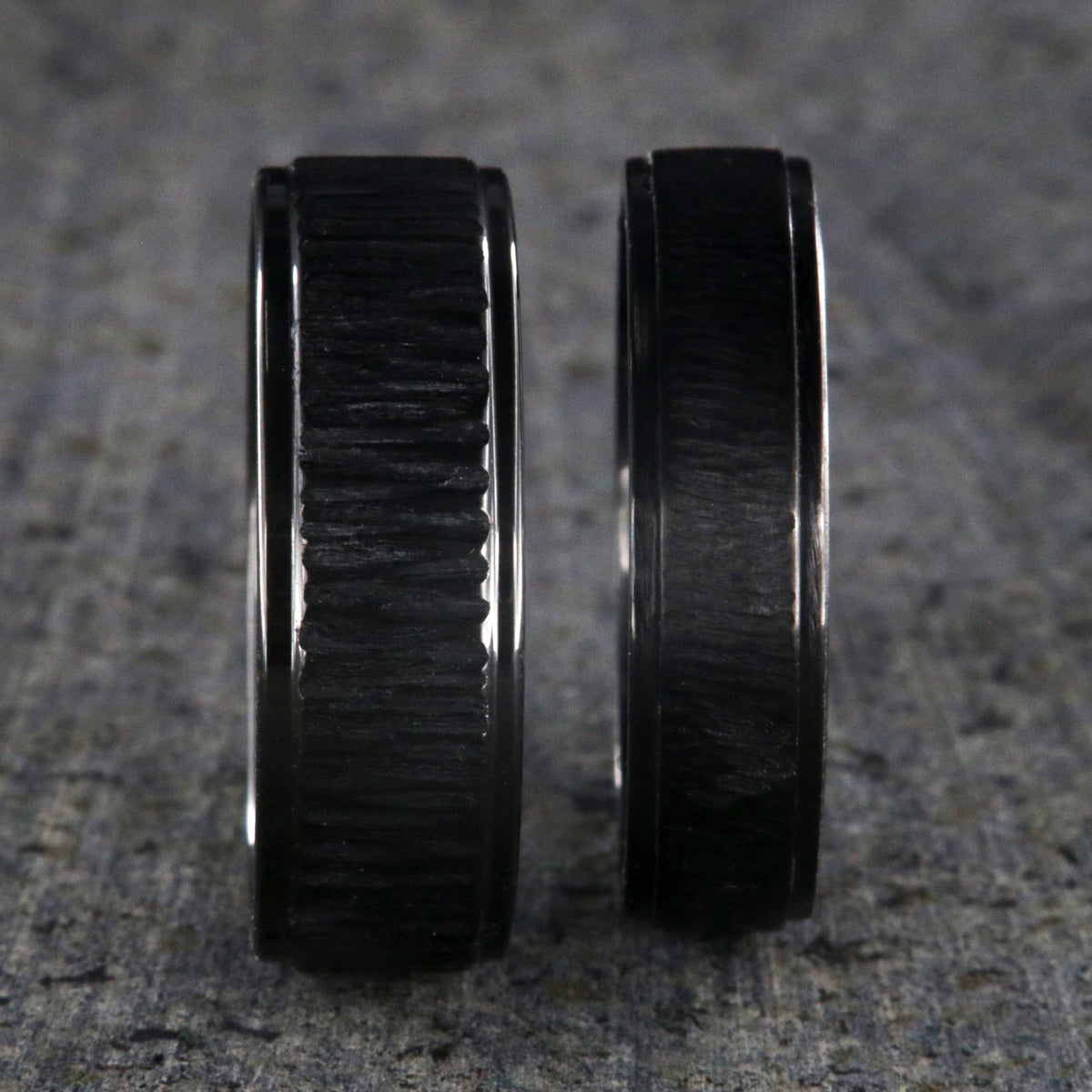8mm and 6mm wide matching black zirconium wedding ring set with a raised center and tree bark finish