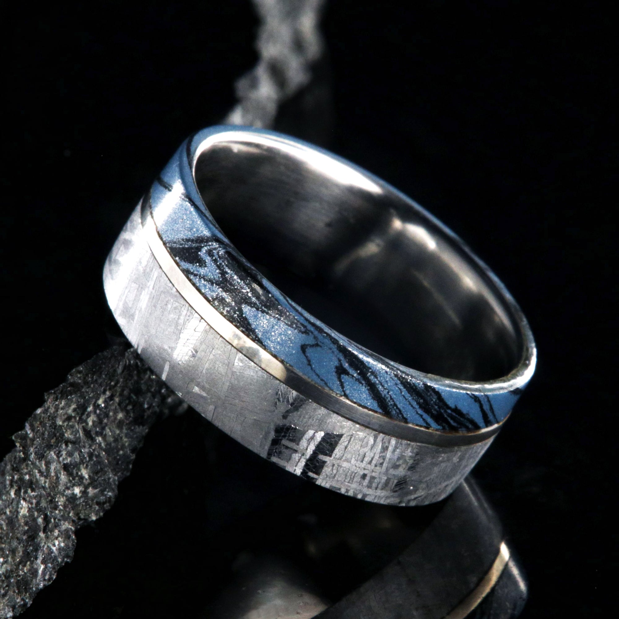 8mm wide wedding band with white gold center inlay with meteorite edge and blue and black cobaltium mokume edge