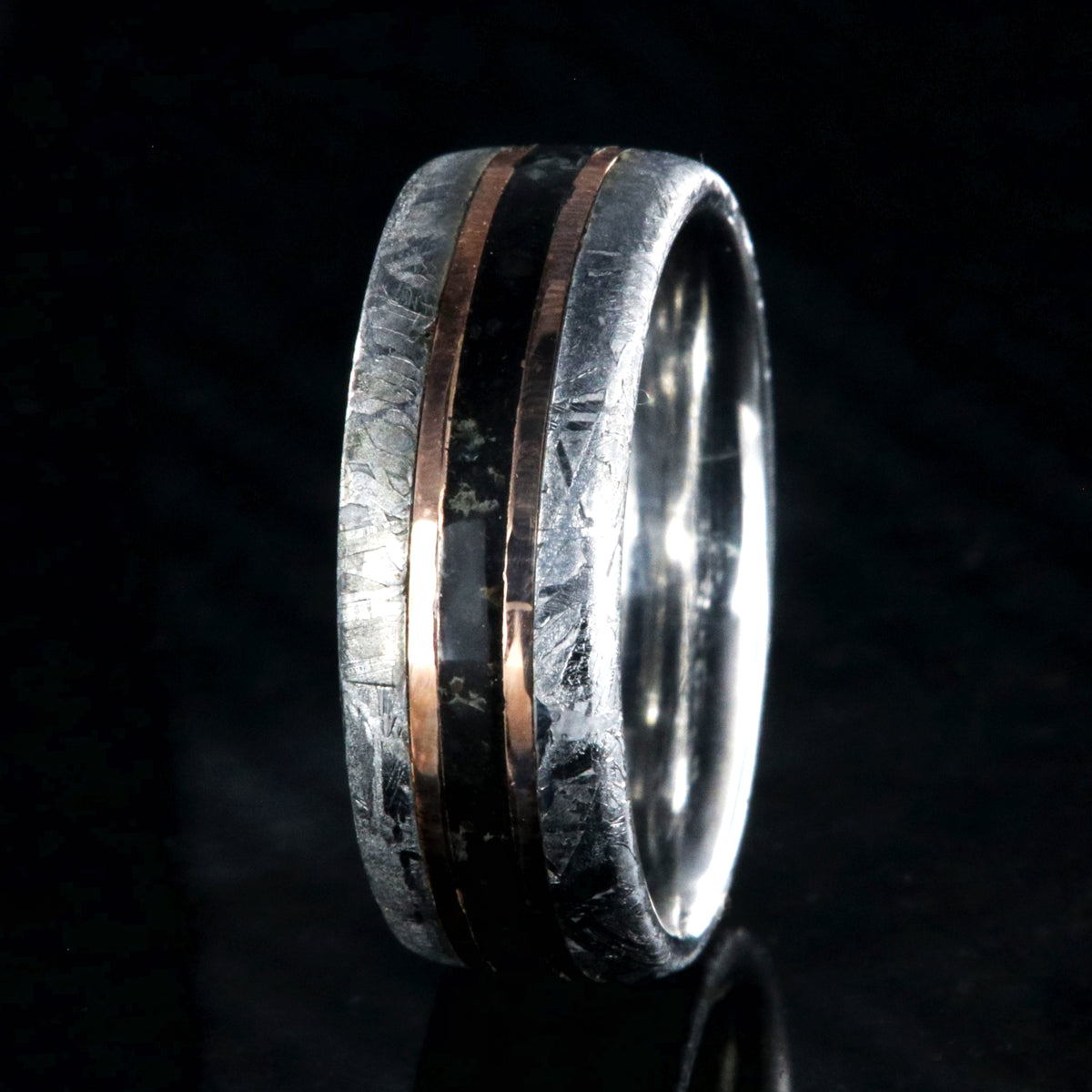 8mm wide men&#39;s wedding band with cobalt sleeve and meteorite edges, a dinosaur bone center inlay with rose gold inlays on either side