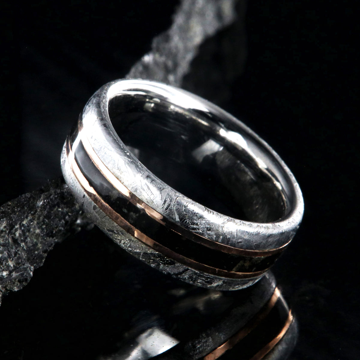 8mm wide men&#39;s wedding band with cobalt sleeve and meteorite edges, a dinosaur bone center inlay with rose gold inlays on either side