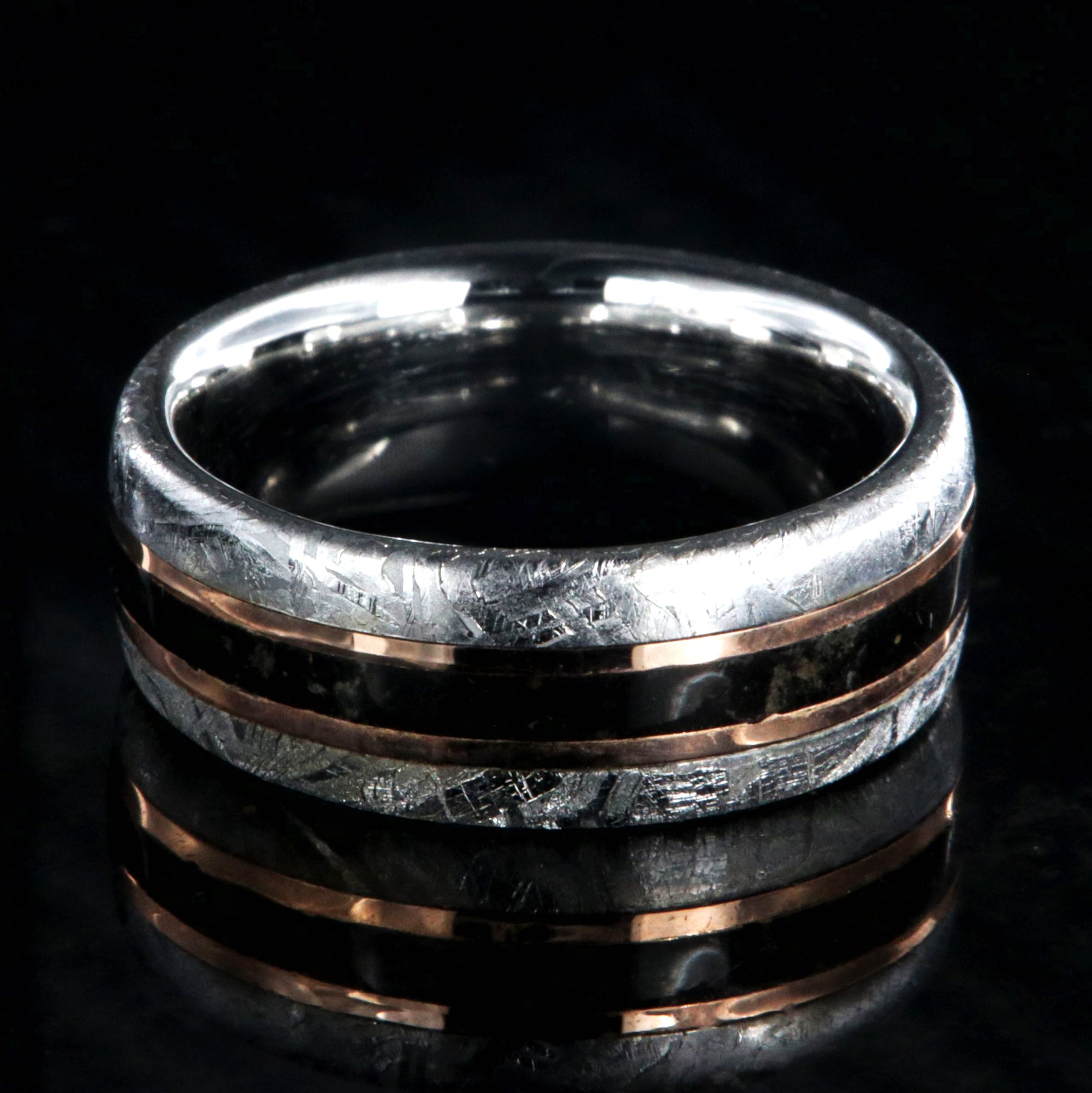 8mm wide men's wedding band with cobalt sleeve and meteorite edges, a dinosaur bone center inlay with rose gold inlays on either side
