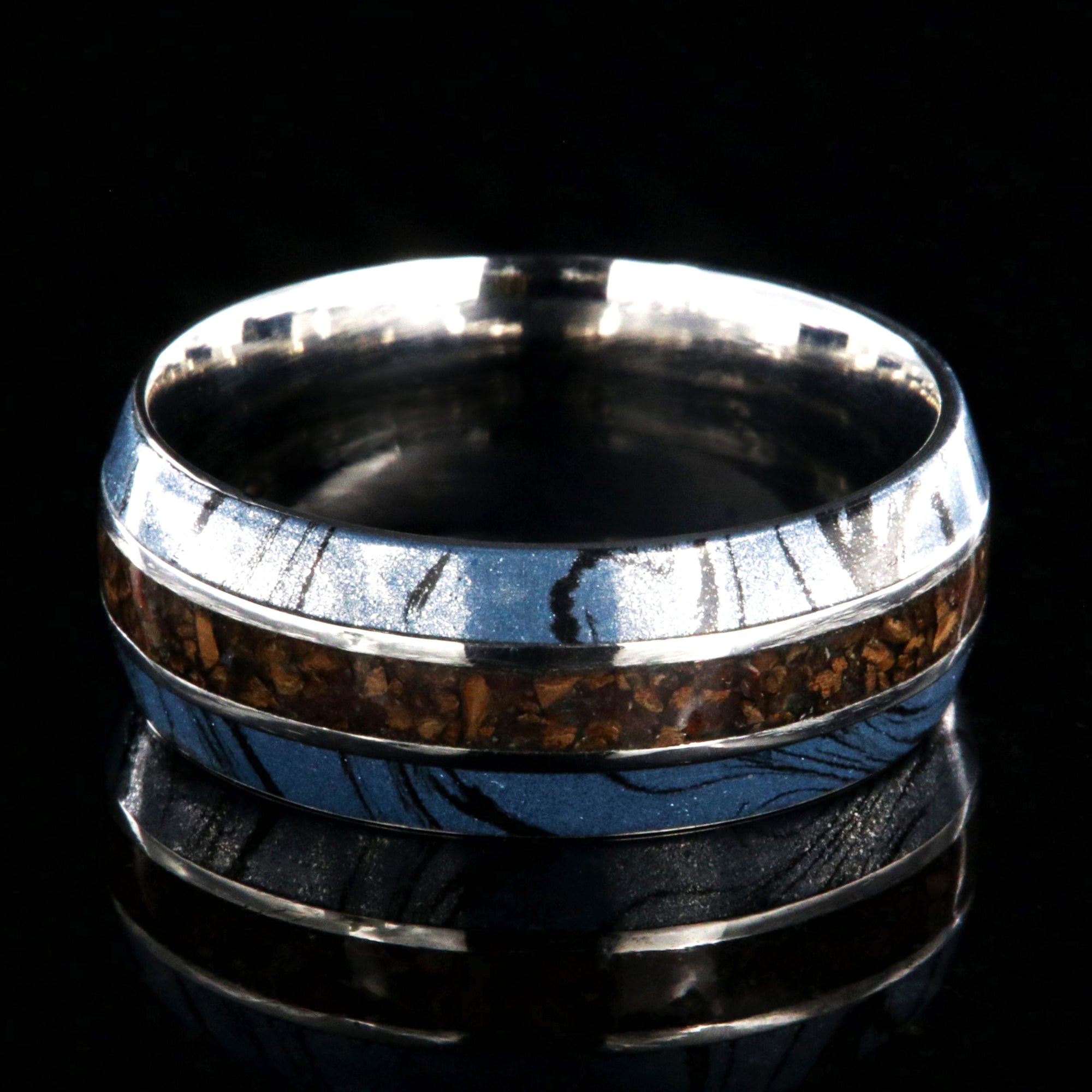 9mm wide ring for men with blue and black cobaltium mokume edges and a dinosaur bone inlay