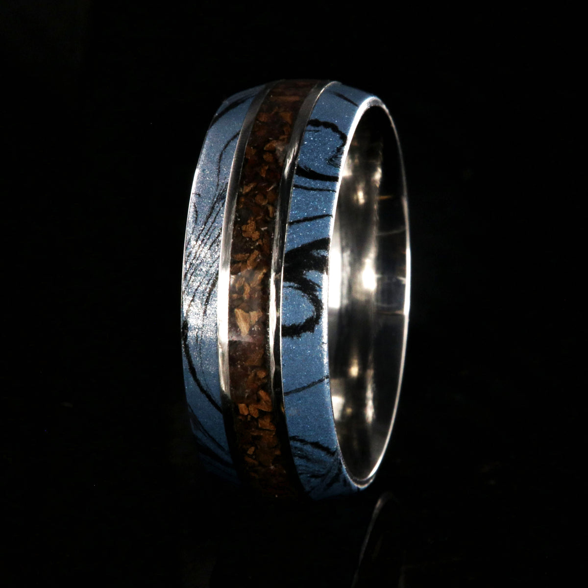 9mm wide ring for men with blue and black cobaltium mokume edges and a dinosaur bone inlay