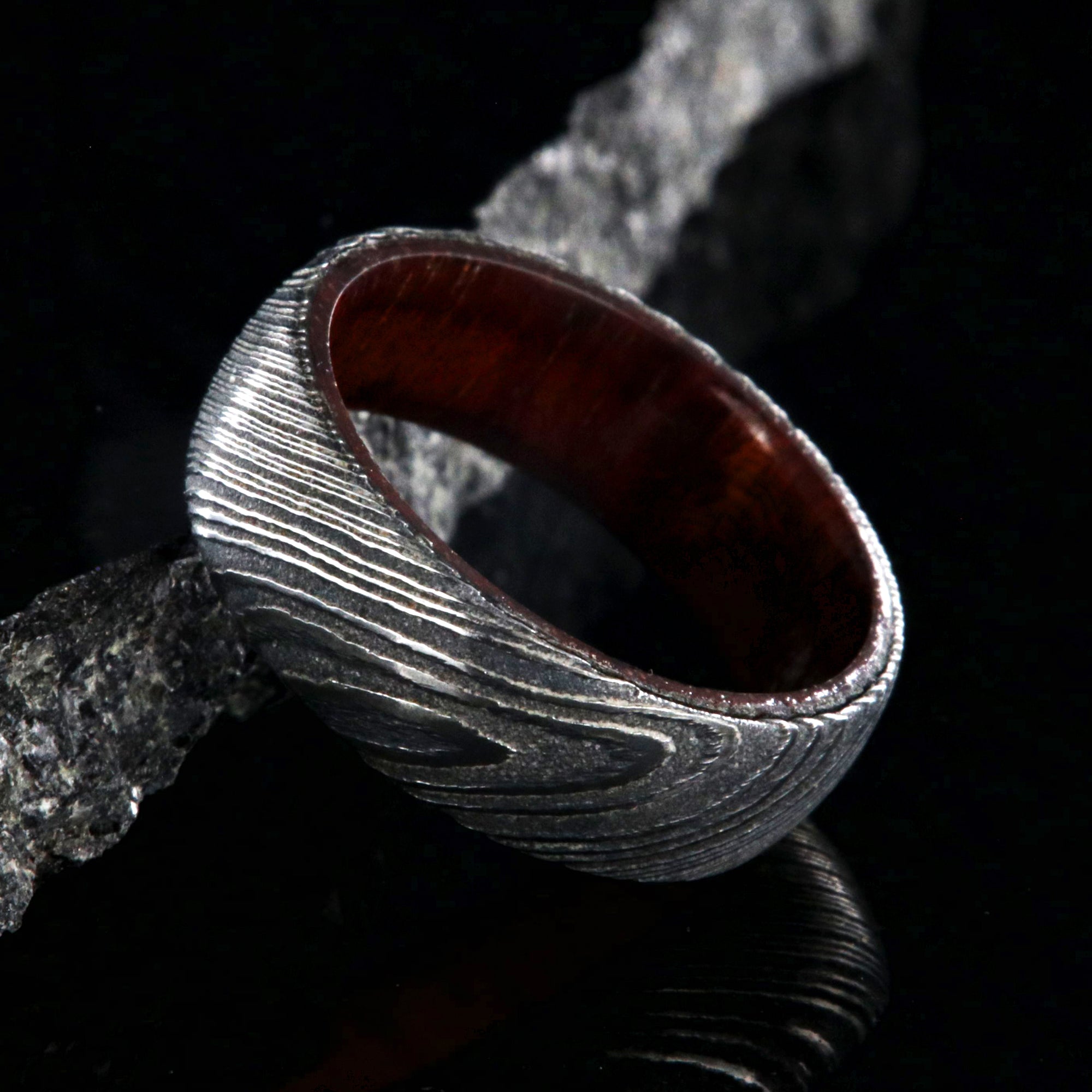7mm wide black Damascus steel wedding band with a bloodwood sleeve with a rounded profile