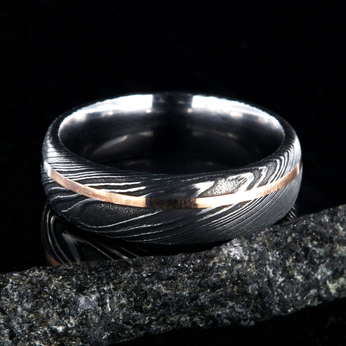 7mm wide black Damascus steel men&#39;s wedding ring with thin rose gold inlay
