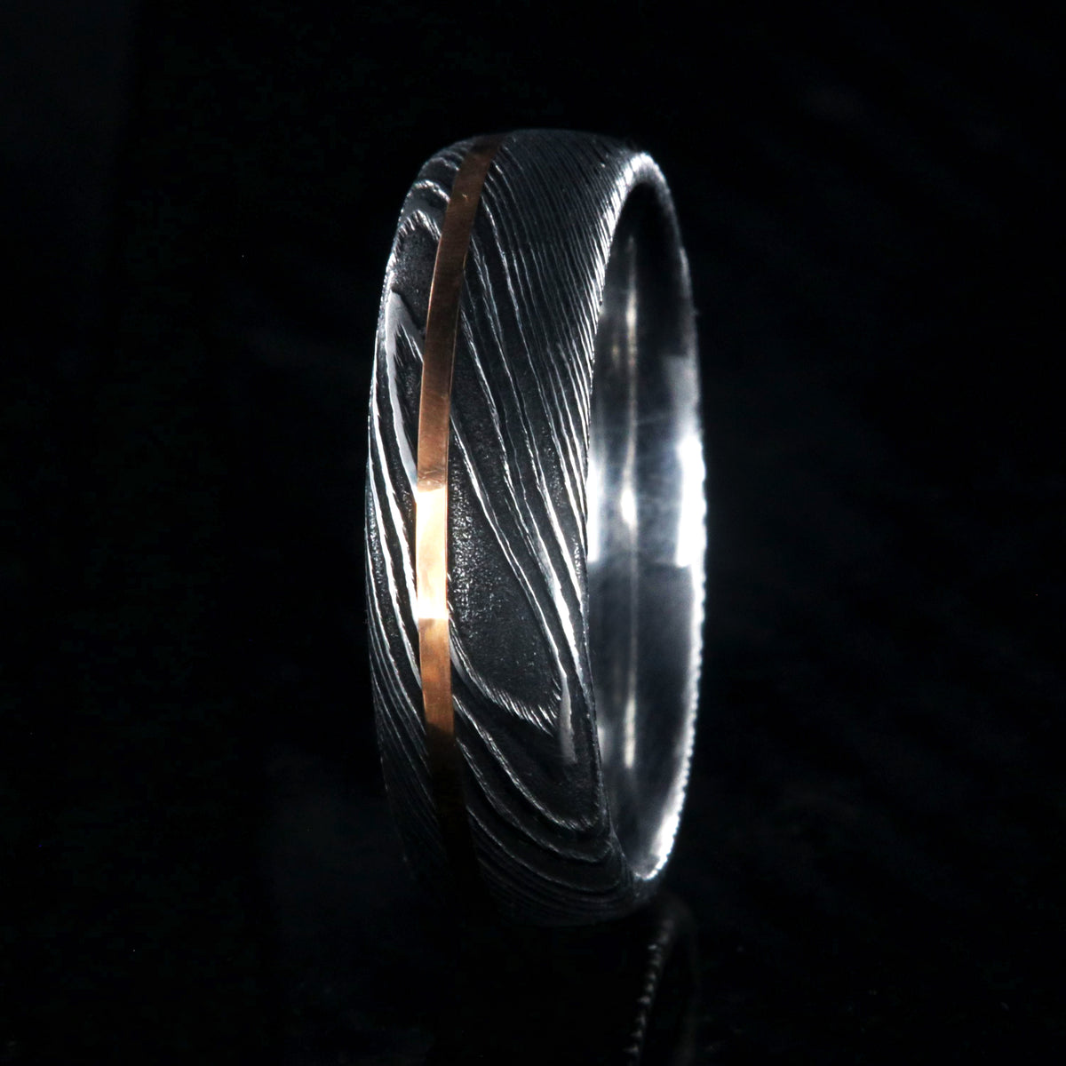 7mm wide black Damascus steel men&#39;s wedding ring with thin rose gold inlay