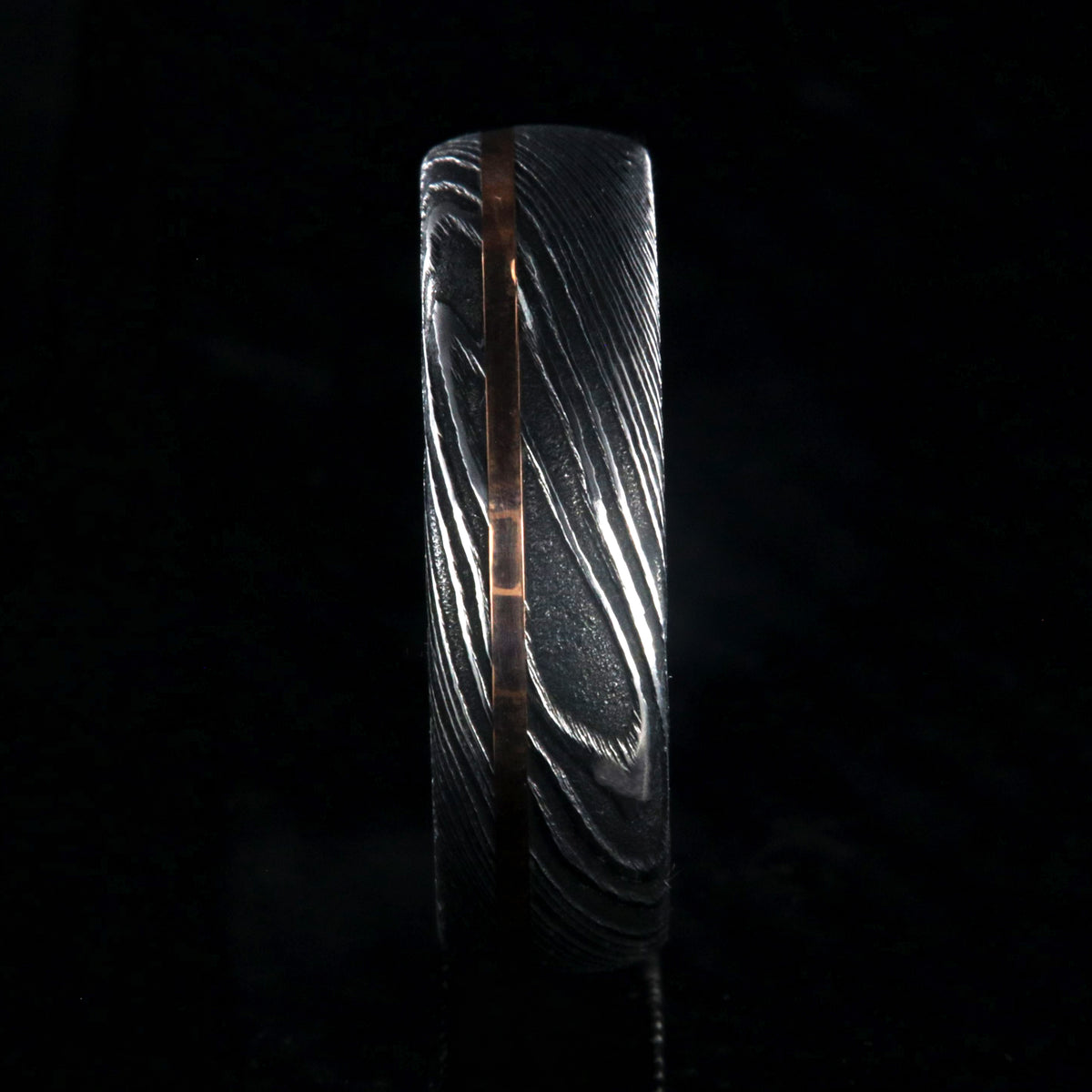 7mm wide black Damascus steel men&#39;s wedding ring with thin rose gold inlay