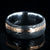 8mm wide black Damascus steel wedding band with a wide rose gold inlay with hammered finish and polished inside