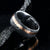8mm wide black Damascus steel wedding band with a wide rose gold inlay with hammered finish and polished inside