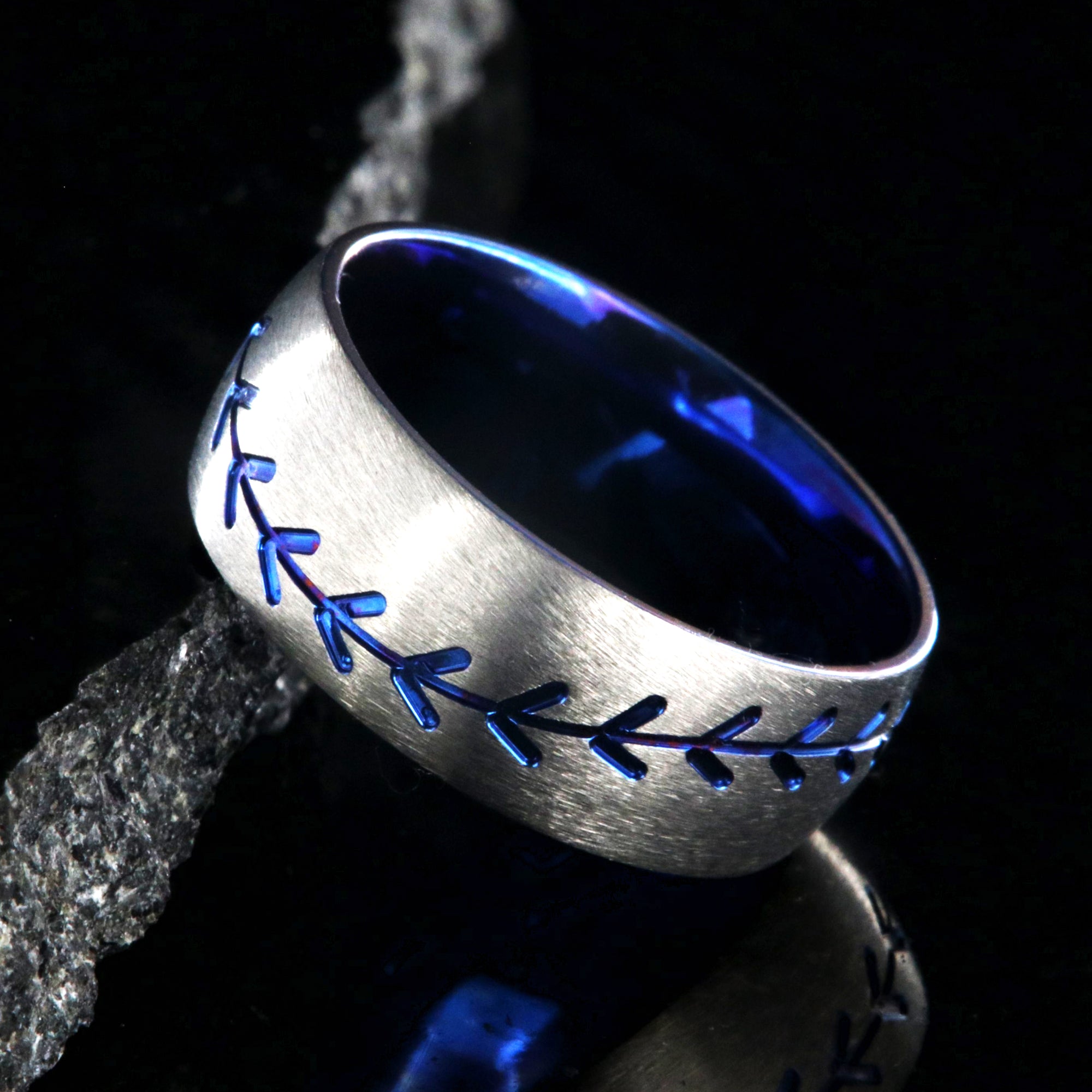 8mm wide titanium baseball ring with blue baseball stitching and a blue sleeve