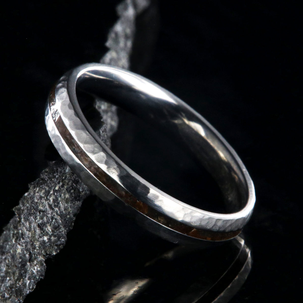 4mm wide titanium wedding band with hammered texture and a 1mm wide t-rex fossil inlay