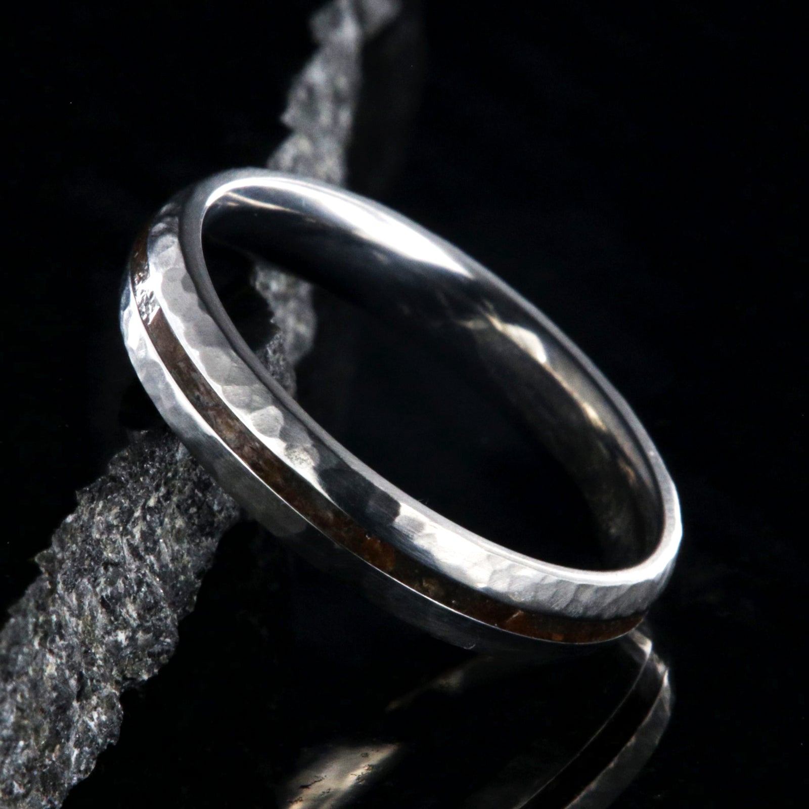 4mm wide titanium wedding band with hammered texture and a 1mm wide t-rex fossil inlay