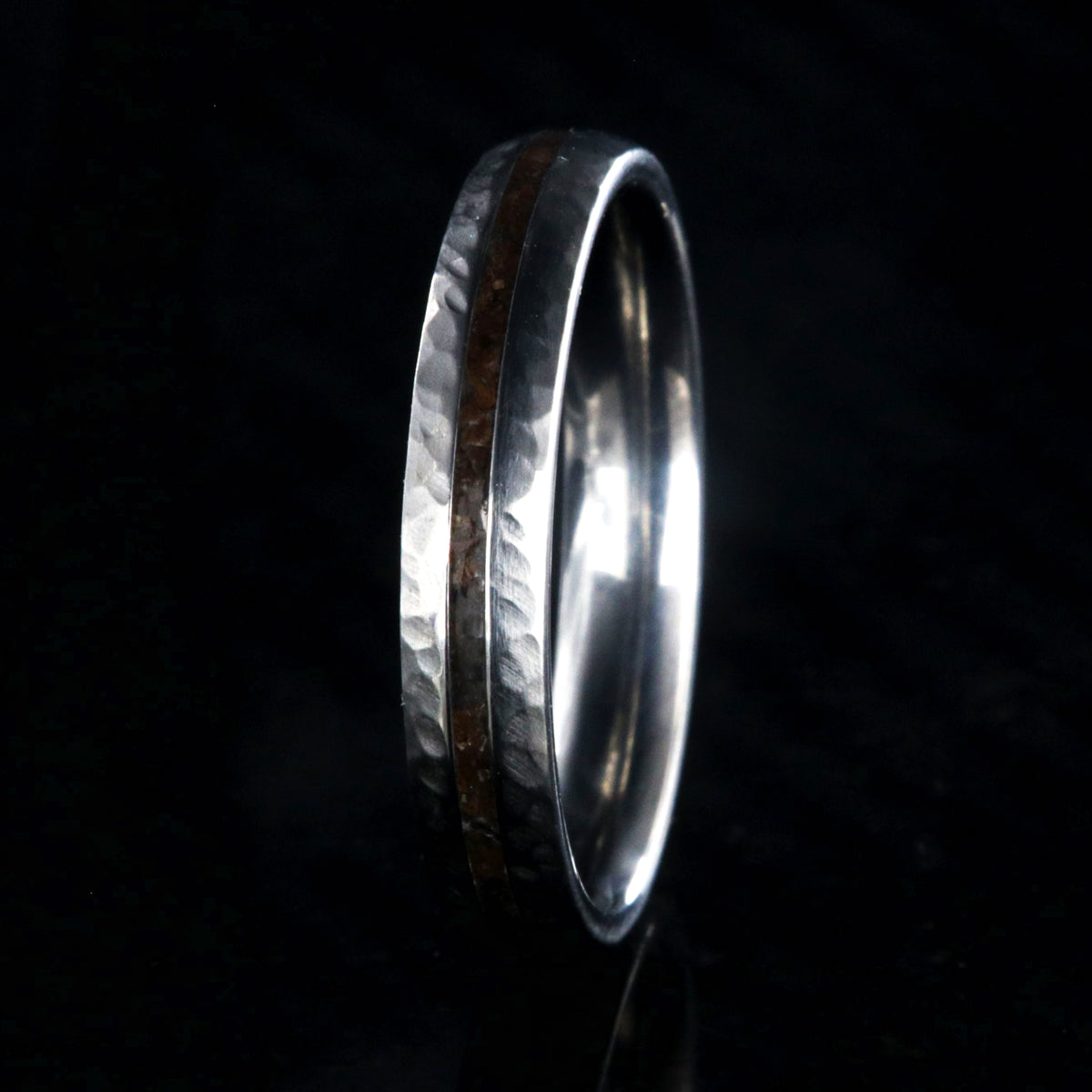 4mm wide titanium wedding band with hammered texture and a 1mm wide t-rex fossil inlay