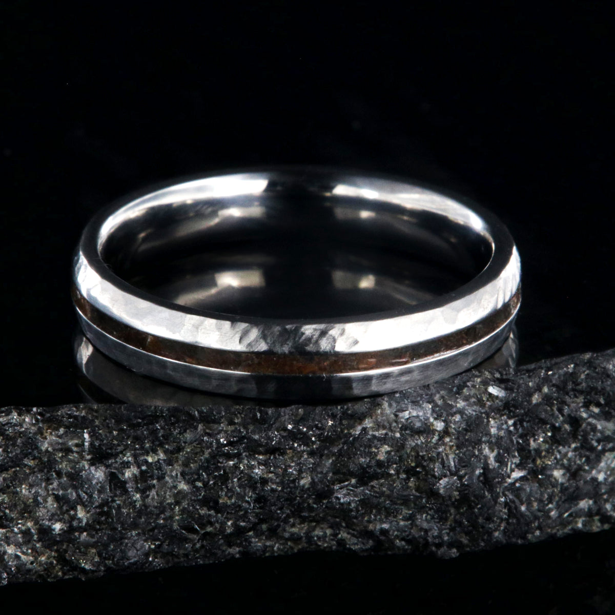 4mm wide titanium wedding band with hammered texture and a 1mm wide t-rex fossil inlay