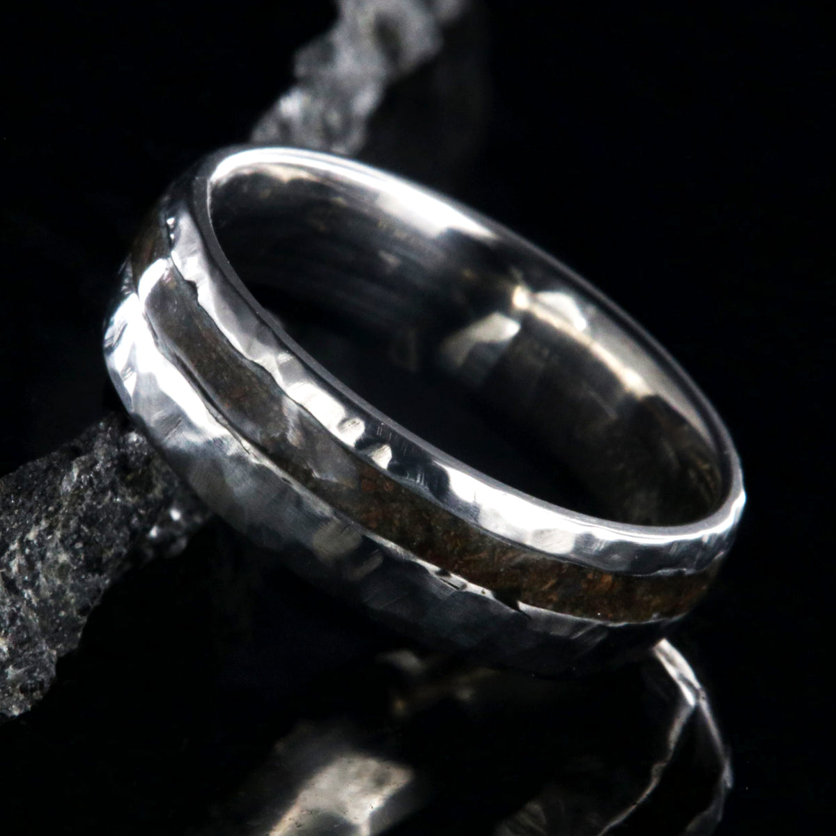 7mm wide titanium wedding band with hammered texture and an off-center 2mm wide t-rex fossil inlay