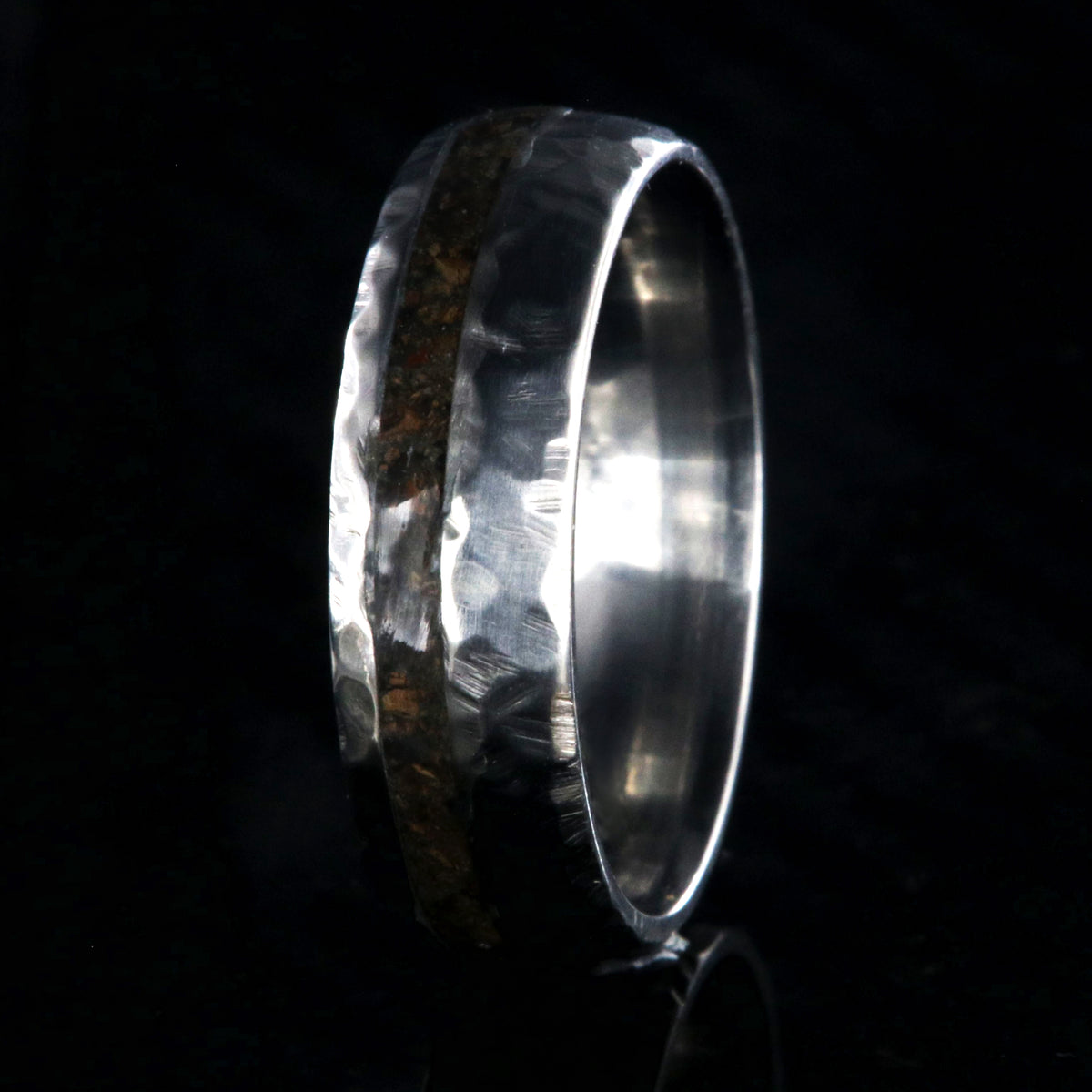 7mm wide titanium wedding band with hammered texture and an off-center 2mm wide t-rex fossil inlay