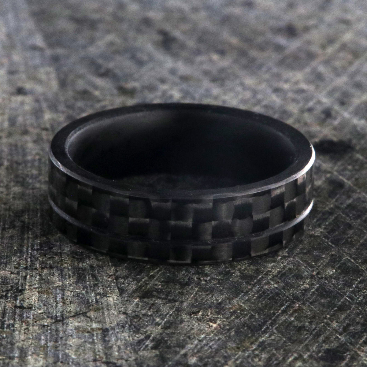 7mm wide black carbon fiber ring with an off-center groove and flat profile