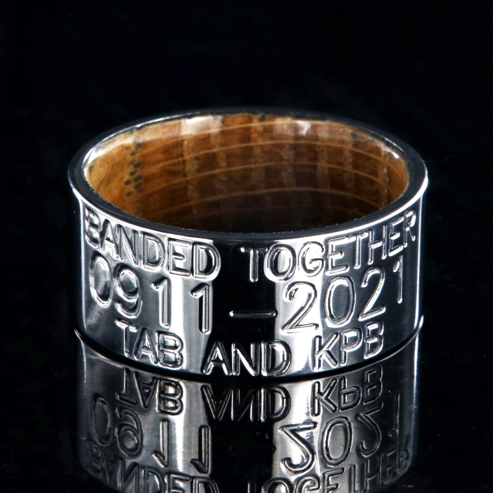 10mm wide titanium duck band with 3 lines of personalized text and a whiskey barrel sleeve