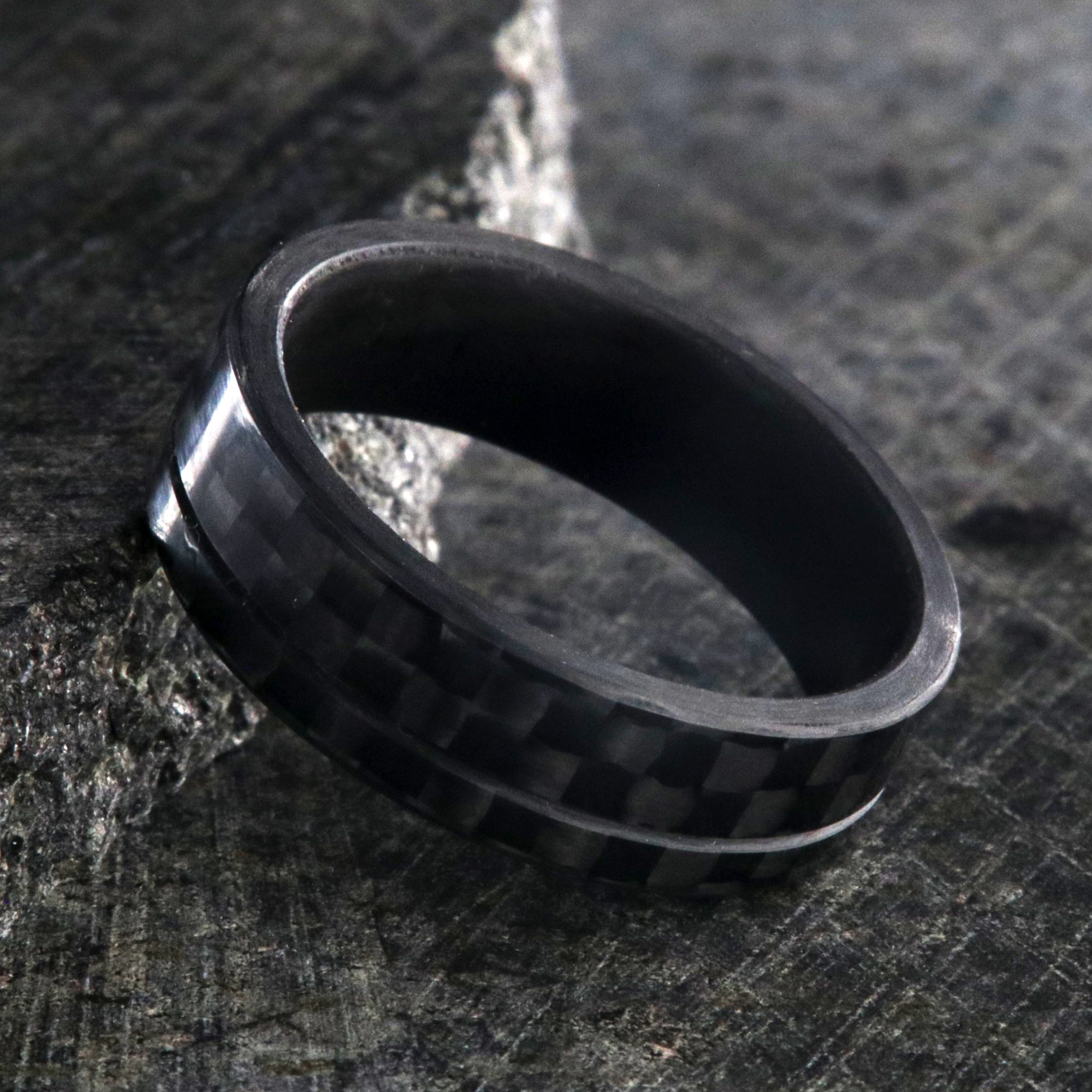7mm wide black carbon fiber ring with an off-center groove and flat profile