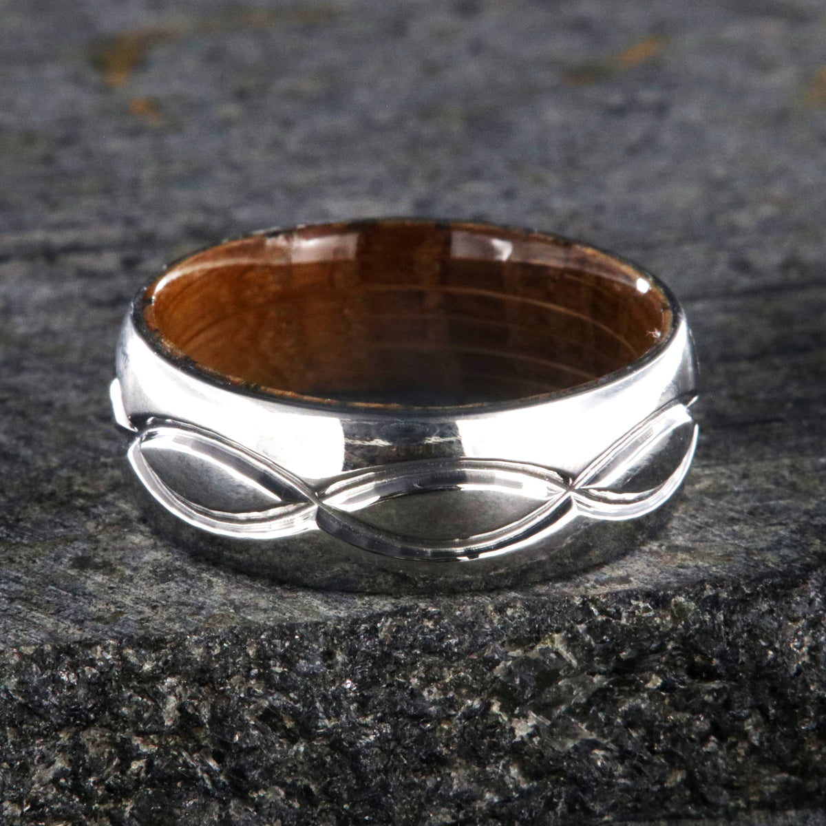 8mm wide titanium wedding band with a milled infinity design with a whiskey barrel sleeve