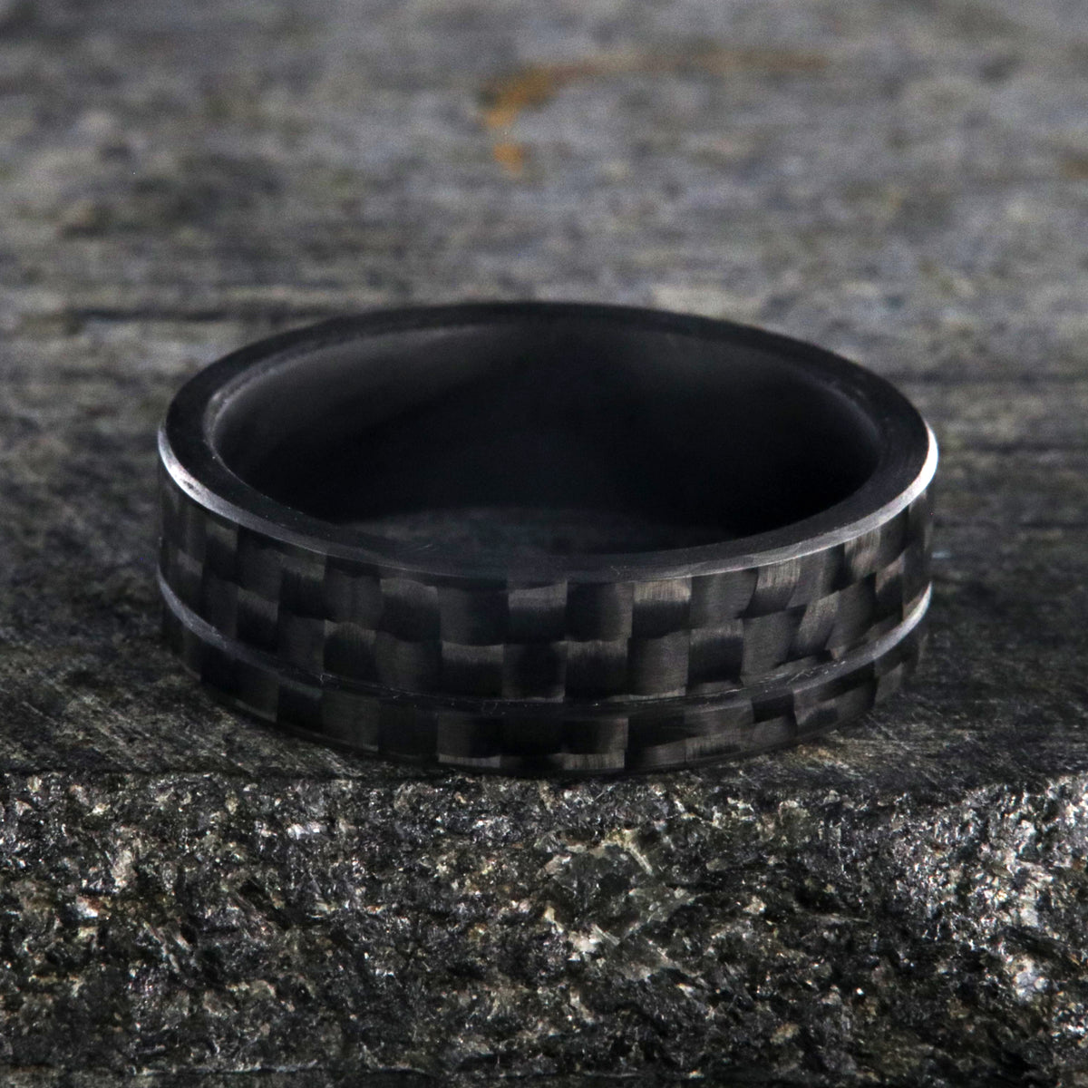 7mm wide black carbon fiber ring with an off-center groove and flat profile